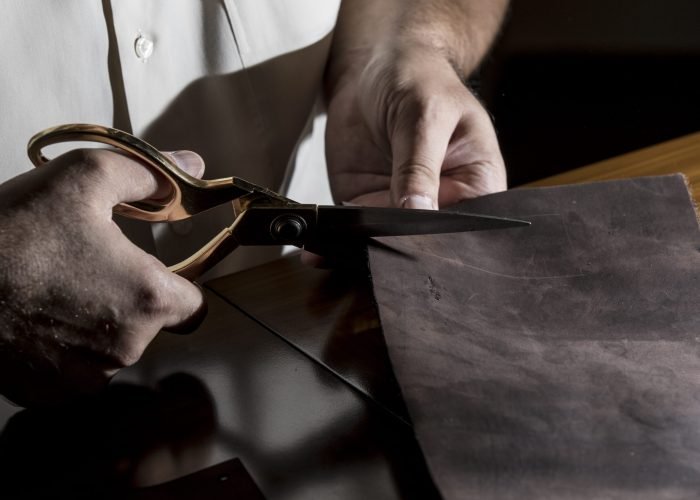 Tailor cutting leather with scissors Tailor cutting leather with scissors. High quality photo